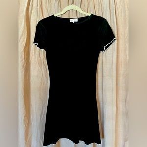 Black minidress with white white seams on the bottom and around the sleeves.